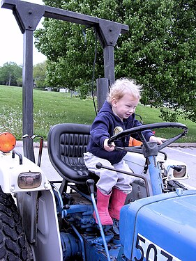 Child playing on old tractor Kansas USA