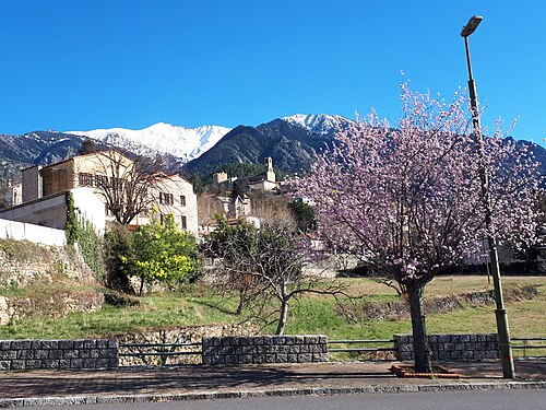 Vernet-les-Bains et les Pics du Canigou (à gauche) (2785m) et Quazemi (à droite). La faille de la Têt passe de gauche à droite derrière le village. Ce point de vue se situe à une altitude de 620m, à proximité de la rivière Cady. L'église se trouve au centre du village médiéval, qui repose lui-même sur des formations édiacariennes contenant du minerai de fer.