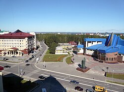 Näkymä Hanty-Mansijskistä. Sinikattoisessa rakennuksessa toimii Geologia-, öljy- ja kaasumuseo. Sen edessä on Länsi-Siperian öljykentät löytäneen ja sosialistisen työn sankariksi nimetyn geologi Farman Salmanovin patsas.