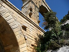 Mampostería de la ponte, amosando los bloques de piedra que sobresalen que s'utilizaron pa sofitar l'andamiaxe mientres la construcción de la ponte.