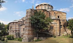 A color photograph of a domed stone structure with a tree at front center