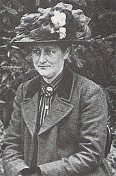 Photographie noir et blanc de Beatrix Potter portant un chapeau à fleurs