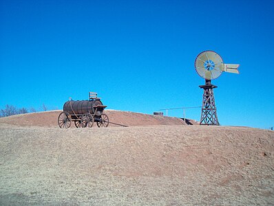 An antique functioning windmill and a cart for transporting water