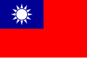 A red flag, with a small blue rectangle in the top left hand corner on which sits a white sun composed of a circle surrounded by 12 rays.