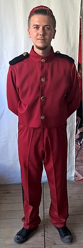 Personne habillée avec le costume rouge du personnage de Spirou et d'un calot rouge et noir