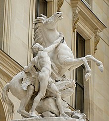 Statue en marbre montrant un cheval cabré tenu par un homme nu portant un carquois.