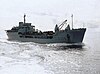 a naval transport ship carrying many vehicles under way in a calm sea