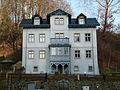 Wohnhaus mit Stützmauer in offener Bebauung