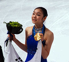 Female figure skater showing her gold medal