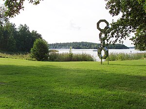 Södergarns strandområde med skulptur uppbyggd av Handelsbankens logotyp. Vy mot Södergarnsviken och Bosöns båtklubb.