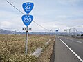 国道230号・国道37号との重複区間を示す標識、奥側に重複路線表示の案内標識・方面及び距離（106-A）（長万部町旭浜、2019年3月撮影）