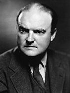 A photographic portrait of a balding Edmund Wilson in a suit, white shirt and tie.