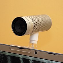 Cylindrical metal camera mounted on a laptop