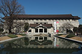 Photo d'un bâtiment longiligne, avec au premier plan, un bassin rectiligne menant à l'entrée du bâtiment.