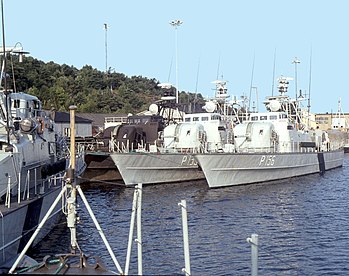 Tidig morgon för 5:e Patrullbåtsdivisionens Huginklass patrullbåtar som ligger förtöjda vid ÖrlbV Nya Varvet i Göteborg sommaren 1982. Närmast kaj, och först ut med nya kamouflagefärgerna ligger lagfartyget HMS Hugin (P151). Utanför finns HMS Vale (P155) och ytterst HMS Vidar (P156). Längst till vänster syns styrbordsidan av HMS Mysing (P158), och gösstaken tillhör HMS Mode (P154).