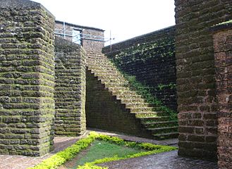 A escada leva ao topo do muro do forte. Note que todo o forte é feito com material laterita.