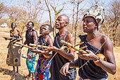 Tanzania, 2016. A line of musicians play the zeze, bowed with a stick.