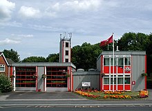 A grey and red, very angular and clean looking prefabricated building of two bays.