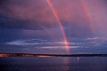 L'arcobaleno primario e il secondario sono visibili, come anche un primario riflesso e un appena visibile arco secondario riflesso.