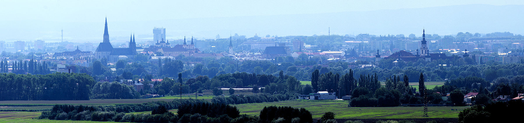 Panorama Olomouce od severovýchodu s přehledem výškových budov. Zleva dóm svatého Václava, budova vodojemu (pod ním kostel svatého Michaela a kostel Panny Marie Sněžné), věž radnice, kostel svatého Mořice a vpravo klášter Hradisko.