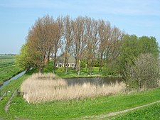 Stolpboerderij in het veld gezien vanaf de dijk