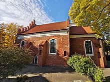 A small brick church, surrounded by trees