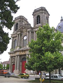 Photo d'une cathédrale de style roman et gothique avec des arbres en premier plan.