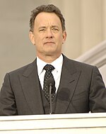 Foto Tom Hanks berdiri di belakang podium di Lincoln Memorial pada 2009.