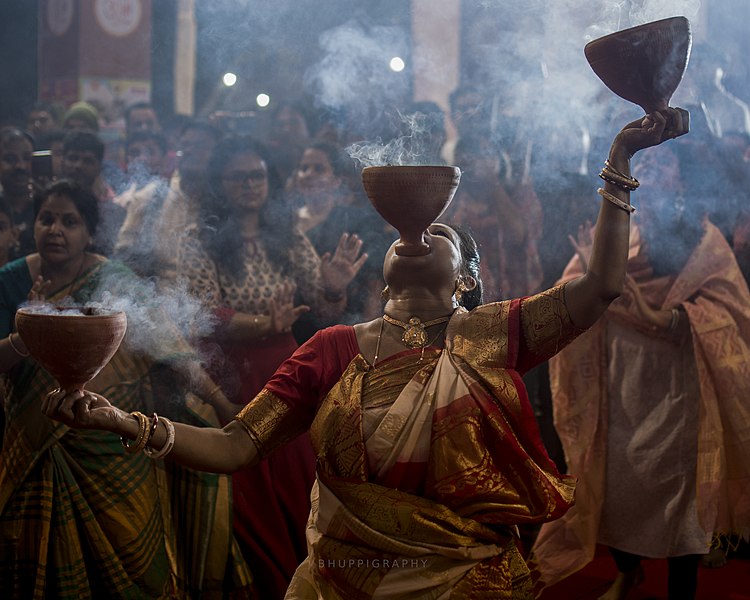 Women performing traditional Dhunachi ritualized dance worship by Bhuppigraphy.