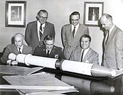 Beamptes met Explorer 1-model by Redstone Arsenal, insluitend genl.majoor John Medaris (3de van links), Walter Haeussermann, Wernher von Braun en Ernst Stuhlinger