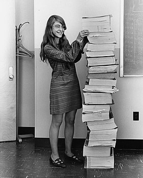 #6: Margaret Hamilton standing next to the navigation software that she and her MIT team produced for the Apollo Project. Attribution: Draper Laboratory; restored by Adam Cuerden. (public domain)