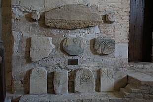 Photographie sur laquelle apparaît des fragments de sarcophages d'époque mérovingienne, dont celui de Chadoaldus. Vestiges actuellement conservés et exposés dans l'enceinte de l'église d'Isle-Aumont.