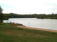 Vue d'un plan d'eau aménagé en base de loisirs.