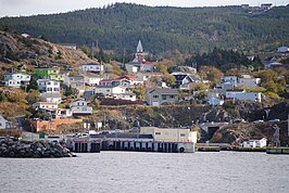 Zicht op de haven van Portugal Cove met aanschuivende auto's op Ferry Terminal Road. De brug over de Main River (rechts) en het bovenste gedeelte van de waterval (uiterst rechts) zijn zichtbaar.