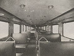 Photographie en noir et blanc montrant l'intérieur de l'autorail avec plusieurs rangées de sièges alignés.