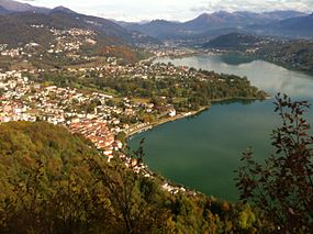 Rigardo al direkte de la Flughaveno de Lugano, Vernate situas sur la monteto maldekstre supre en la bildo.