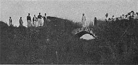 Photo d'un pont de pierre presque entièrement masqué par la végétation