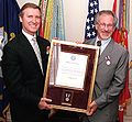 Secretary of Defense William S. Cohen presents a framed citation accompanying the medal given to Steven Spielberg.