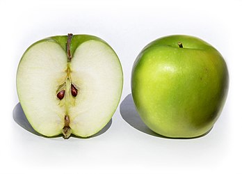 Deux pommes de la variété Granny Smith, la première coupée en deux, la seconde entière. (définition réelle 1 672 × 1 200)