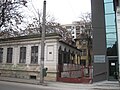 Maison bucarestoise du début du XIXe siècle (monument historique) avenue Șerban Vodă, devant un immeuble du début du XXe siècle, voisine d'un immeuble du XXIe siècle et sur fond d'immeubles des années 1960.