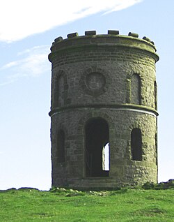 Stone tower on grass-covered hilltop