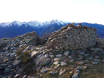 Ruines de la chapelle Santa Anna dels Quatre Termes. Au fond : le massif du Canigou.