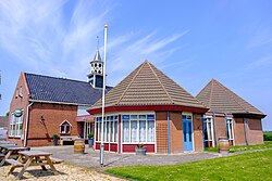 Voormalige lagere school uit 1868, in 1956 verbouwd tot dorpshuis 'Fivelhoes' en vervolgens nog sterk uitgebreid