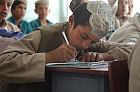 Photo of a boy taking notes at school