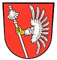 Gemeinde Ebing In Rot ein silberner Flug mit seitlich daraus hervorwachsendem silbern bekleidetem Arm, der einen oben mit einer silbernen Muschel belegten silbernen Jakobsstab hält.[34]