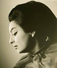 Onstage publicity photo. Profile of a woman in stage makeup, looking down, with bouffant black hair, swept back.