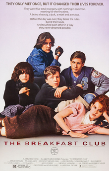 The five main characters huddled together, four seated in various poses and a girl lying across in front.