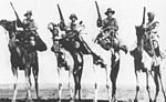 A posed photograph of Australian, British, New Zealand and Indian camel troops