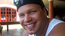 Portrait of Peat in a backwards baseball hat smiling at the camera