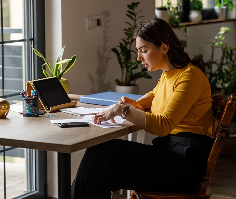 Person wearing a yellow shirt doing their taxes